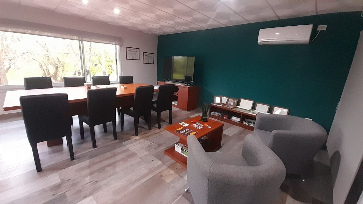 Espacio de estar con sillones grises junto a la sala de reuniones